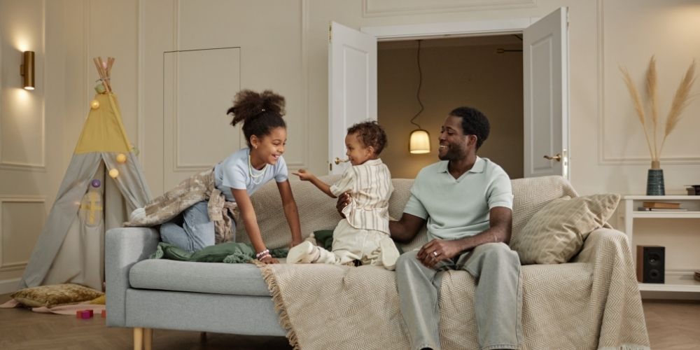 Dad spending time with his kids on the couch.