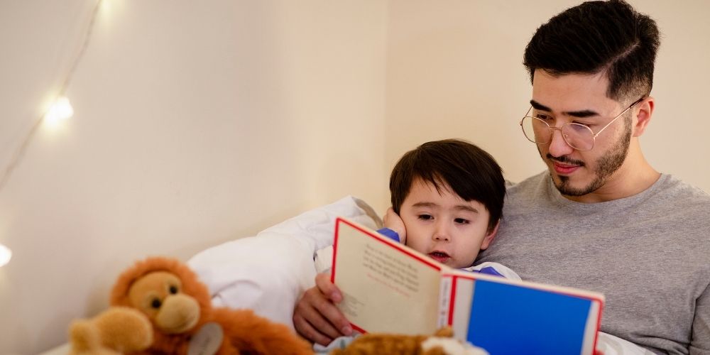 Dad reading book to his kid.